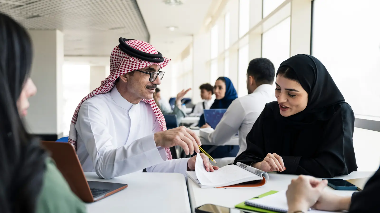 A teacher working through a book with students in a classroom; illustrative photograph